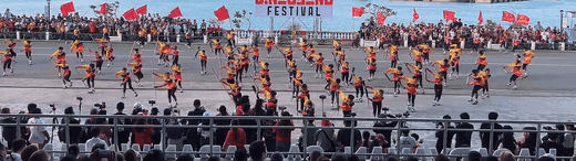 Cry of Jelicuon performers executing explosive synchronized movements with raised flags